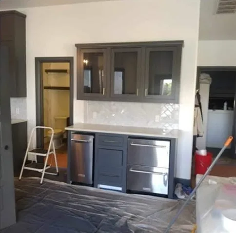 Built-in coffee bar with glass-front upper cabinets painted dark gray