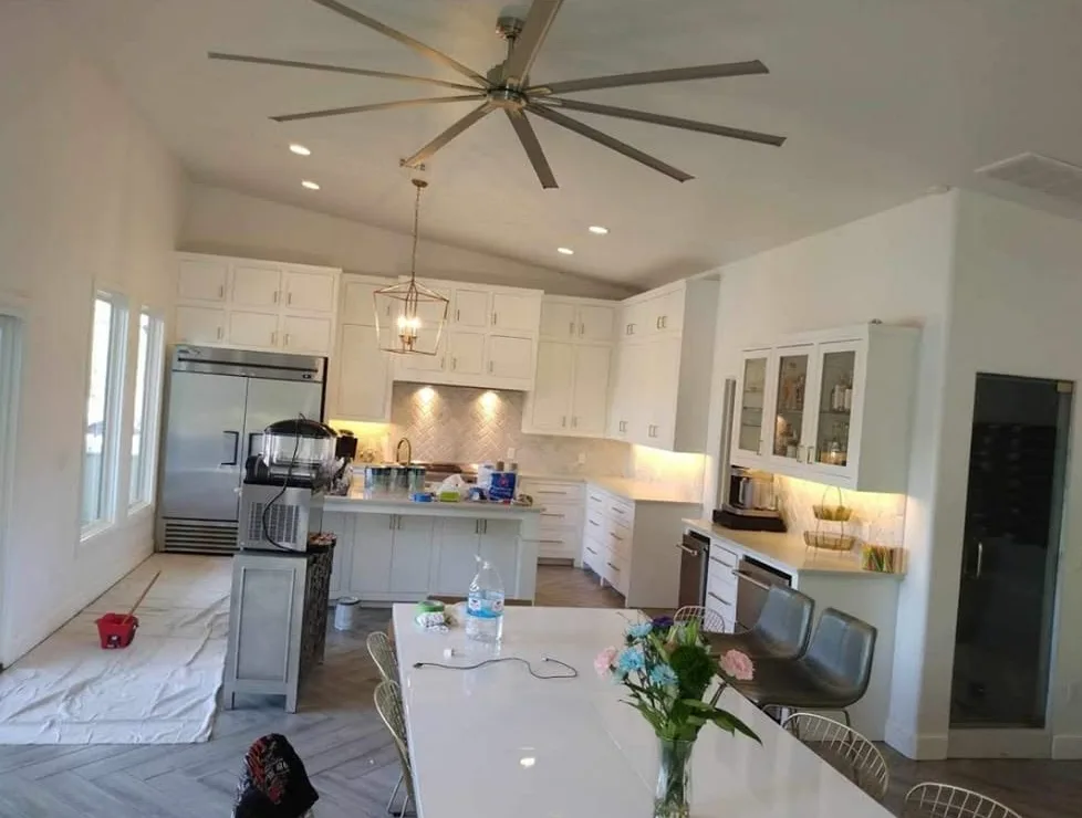 Finished white kitchen remodel with shaker cabinets, glass-front uppers, quartz counters, and herringbone tile