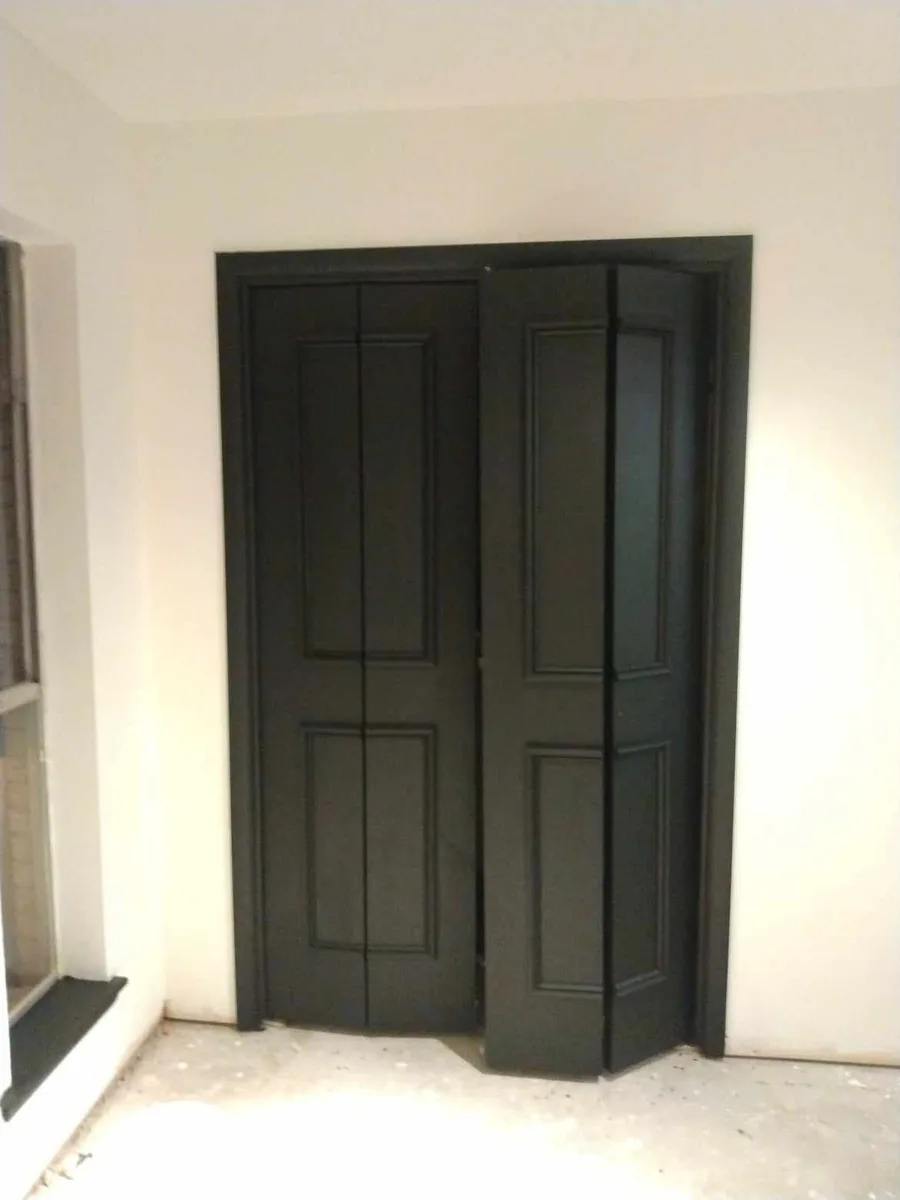 Raised-panel bifold closet doors and trim painted satin black